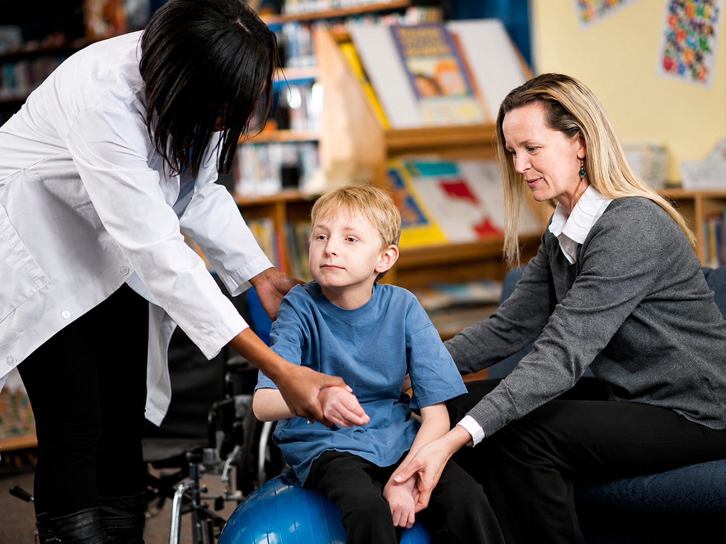 A caregiver and therapist supporting a young boy during a respite session